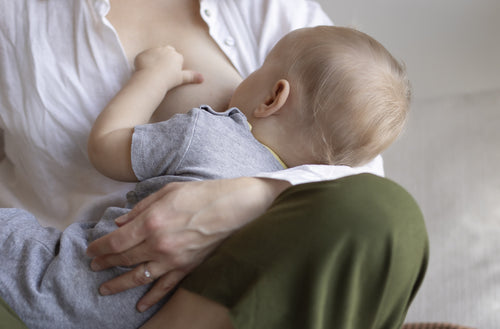 Durante o Agosto Dourado, mulher amamentando o seu bebê que está no colo. 