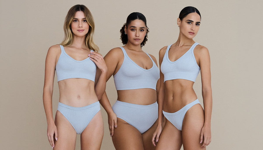 Três mulheres vestem peças ganhadas no chá de lingerie.