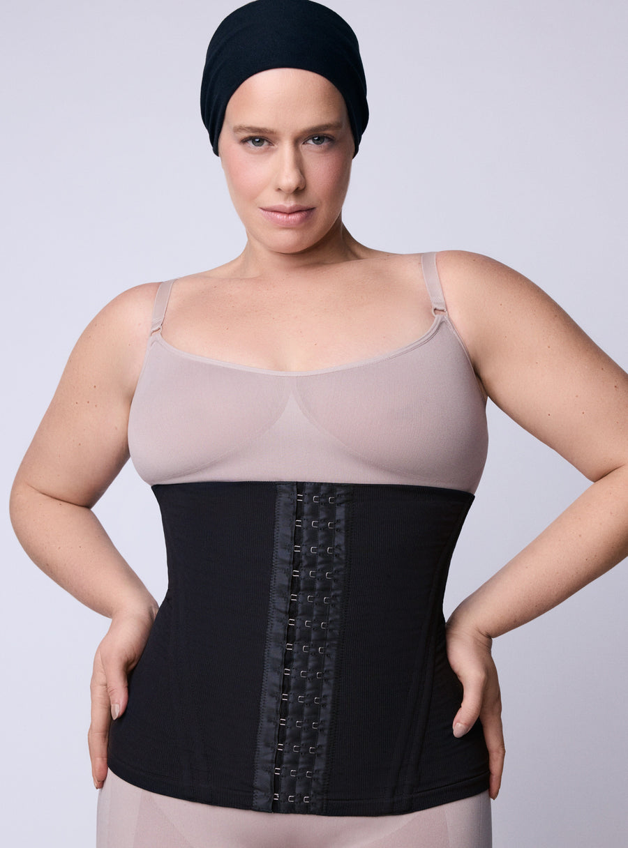 Mulher com a mão na cintura posando com uma cinta modeladora que funciona
