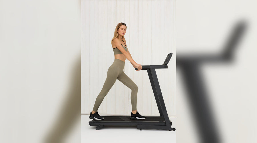 Mulher em cima de usa esteira vestindo uma legging com bolso.