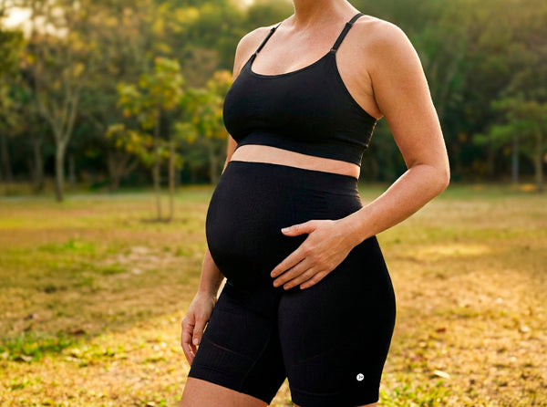 Mulher grávida em um parque usando roupa para gestante