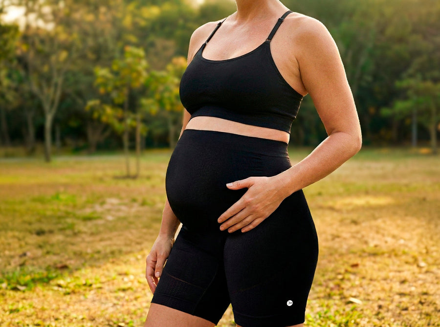 Mulher grávida em um parque usando roupa para gestante