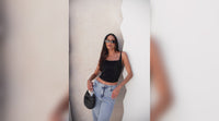 Mulher encostada em uma parede utilizando um corset.