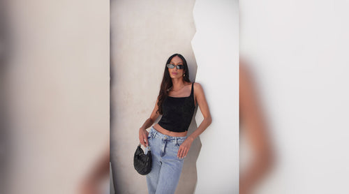 Mulher encostada em uma parede utilizando um corset.
