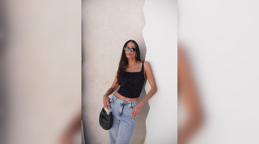 Mulher encostada em uma parede utilizando um corset.